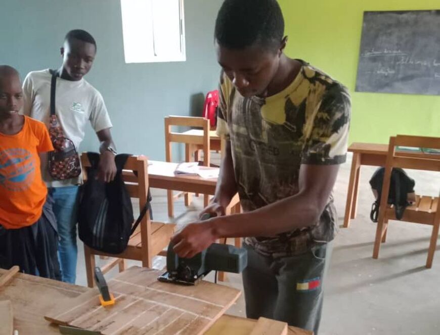 Young man working on wooden workpiece