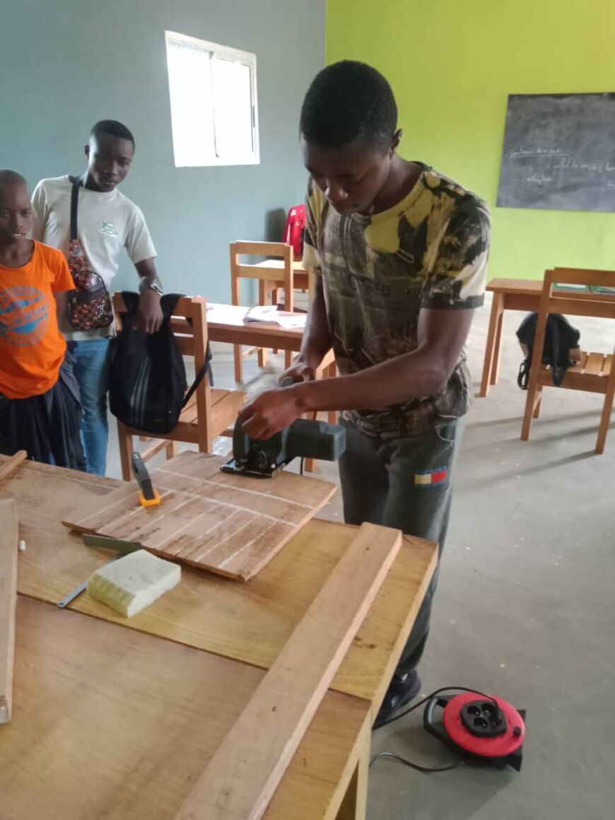 Un jeune homme travaille sur une pièce de bois