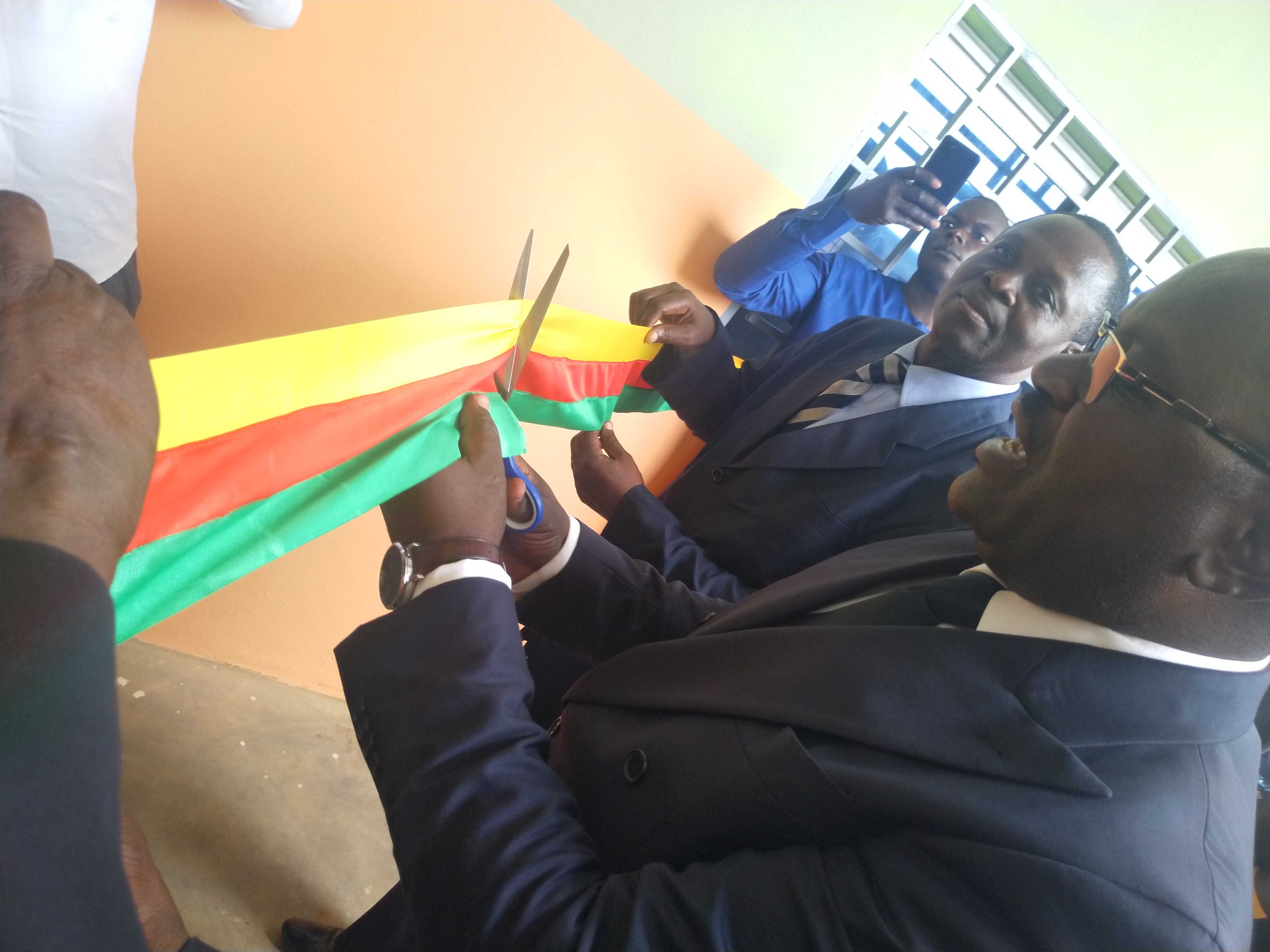 Un ruban (pour l'ouverture de l'école) est coupé avec des ciseaux.